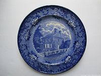 Front view of blue and white historical plate with image of Washington's Headquarters and floral border