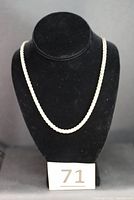 Full view of the chainmail necklace on a black display bust showing its length and style.