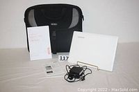 Full lot showing Lenovo Ideapad 110S laptop, user guide, AC adapter, and black carrying bag