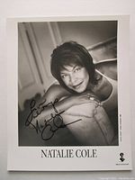 Black and white 8x10 autographed photo of Natalie Cole leaning on armrest.
