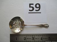 Full view of bon-bon spoon next to ruler showing length approximately 4.75 inches
