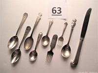 Photo showing all ten vintage silver plate items: six spoons, two forks, and one knife with pirate motif.