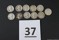 Full overview of all 11 coins arranged in two rows on a black background with lot number card in view.