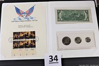 Full lot view showing the set including the $2 bill, three coins, and commemorative stamp sheet mounted on display card.