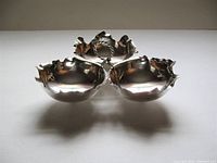 Front view of three connected bowls with twisted handle on white background