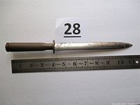 Full length side view of dagger next to ruler showing total length near 11 inches