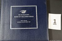 Navy blue presentation binder cover with silver Franklin Mint emblem and set title