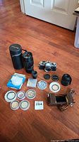 Wide view of the entire lot showing camera, lens, extender, filters, and cases.