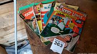 Stack of five comic books including Jerry Lewis, The Man from U.N.C.L.E., John F. Kennedy, Spiderman annual, Cowboy in Africa