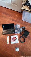 Full lot on hardwood floor showing Sony mini laptop, Creative Zen in original box, strobe light, various cables, and accessories.