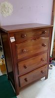 Full front view of the wood secretary desk showing the closed drawers and cabinet structure.