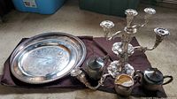 Photo of entire set on dark cloth showing tray, tea set items, and candlestick with damage