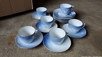 All teacups, saucers, and plates arranged on floor showing set quantity and design