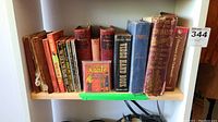 Shelf with assortment of vintage books, varying in condition; includes Little Orphan Annie, Les Miserables, and other titles.