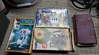 Three vintage model kits stacked on carpet, includes Dongo anime robot, Saracen warriors, and modern German infantry kits, showing box art and labels.