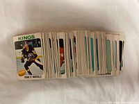 Photo showing front sides of multiple 1975-76 O-Pee-Chee hockey cards, with player images and team names.