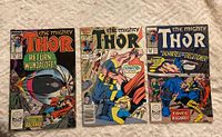 Front view of three vintage The Mighty Thor comic book covers, issues 374, 403, and 406, displaying detailed artwork and titles.