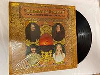 Front cover of Mama's & Papa's Golden Era Vol. 2 vinyl record showing band member portraits and decorative design.