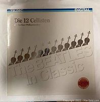 Front cover of the vinyl record 'The Beatles In Classic' featuring 12 cello silhouettes and large embossed text.