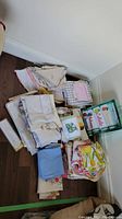 Stack of assorted folded tea towels and napkins, various colors and vintage style