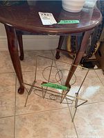 Full view of the wood side table showing curved legs, rounded edge tabletop, and dark brown finish.