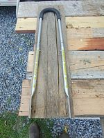 Full length view of the Balance Buddy Bar showing metal bar with black grips and instructional decal.