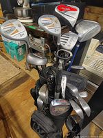 Full set of golf clubs in bag showing the assortment of woods and irons with visible wear.