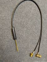 Full view of flexible black hose with attached gas welding torch, showing brass fittings at hose ends.