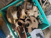 Photo showing multiple trailer wheel hubs in a plastic crate, worn and used condition