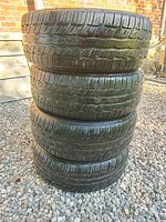 Stack of four used BF Goodrich tires showing tread and sidewalls.