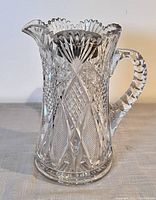 Side view of the cut crystal water pitcher showing the detailed cut pattern and handle.