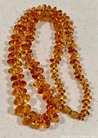 Full view of the Baltic amber bead necklace laid out showing the varying bead sizes and the entire strand.