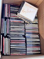 Box with approximately 100 compact discs, showing the varying spine titles and jewel cases with iconic Roy Orbison album on top.
