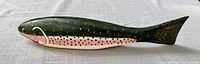 Side view of wooden rainbow trout decoy showcasing painted details.
