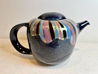 Front and side view of vintage Rosenthal porcelain teapot showing colorful deco stripes and offset handle design.