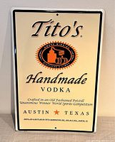Front view of Tito's Handmade Vodka metal sign showing full branding and text.