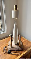 Full view of vintage military trench art table lamp showing main body, wooden base, brass lamp socket, power cord and attached bullet casings.