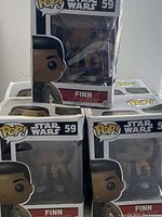 Five boxed Finn vinyl bobblehead figurines from Star Wars Pop! series, model number 59, stacked and arranged for display.