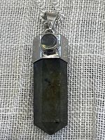 Front view of labradorite crystal pendant set in 925 sterling silver with round labradorite accent above the main crystal, attached to sterling silver chain.