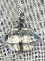 Close-up of the double terminated quartz crystal pendant with 925 sterling silver setting and chain, showing the horizontal silver band holding the crystal.