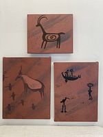 Three primitive indigenous art paintings arranged together, showing different sizes and figure compositions.