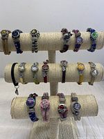 Front and top view of the 17 assorted snap charm bracelets on three tiers; showcasing different styles, colors, and charms.
