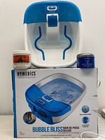 Homedics Bubble Bliss Deluxe footbath on top of its box with Aztec Secret Indian Healing Clay and L'Anza Healing Moisture Hair Masque placed beside it.