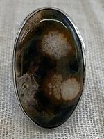 Close-up front view of oval Ocean Jasper stone set in silver plated ring showing detailed orbicular patterns in brown, cream, and black.