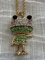 Front view of gold tone frog pendant necklace with black, clear, pink, and green faceted rhinestones, showcasing the movable limbs and detailed faceting.