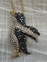 Close-up photo of the penguin pendant showing clear and black faceted rhinestones.