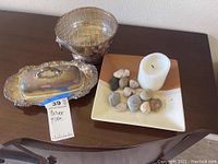 Overall view of the silver plated dish with lid, silver plated bowl, and the plate holding candle and stones.