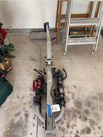 Full view of folded truck bike rack showing central metal bar and side arms with bike mounting straps.