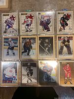 Top view of all 12 hockey cards, a mix of color and black and white with some autographs and golden portraits.