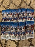 Twelve sealed Marvel Captain America Civil War collectible card packs with necklace dog tags, laid out on carpet.